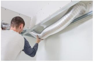 Man installing brand new duct inside room